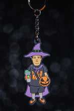 Load image into Gallery viewer, Basic Witch kid keychain with &quot;pumpkin cult&quot; shirt, purple witch hat, purple cape, orange shoes,  pumpkin spice drink, and our signature pumpkin bag in orange and black.  