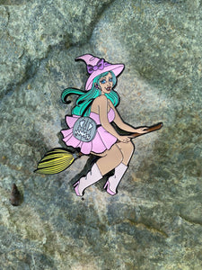 Enamel pin of witch in pink riding a broom.