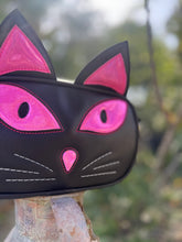 Load image into Gallery viewer, Black cat-shaped purse with pink eyes and ears on a blurred natural background