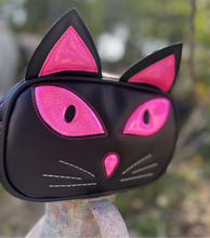 Load image into Gallery viewer, Black cat-shaped purse with pink accents on a blurred natural background