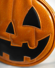 Load image into Gallery viewer, Orange Glitter vinyl and Black vinyl happy pumpkin face bag. Close up of half face.