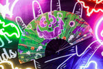 Green hand fan open next to neon signs.