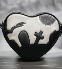 Load image into Gallery viewer, Heart shaped bag with graveyard silhouetted on white background with glitter grey moon. 