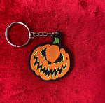 Detailed close up of keychain of jack-o-lantern with Bad Company face.