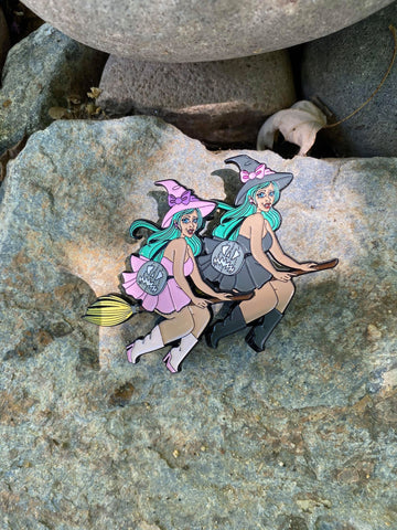 Enamel pins of two witches with mint hair riding brooms. 