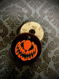 Front and back view of phone grip displaying the Bad Company jack-o-lantern.
