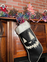 Load image into Gallery viewer, Black holiday stocking with white top, white glitter edging, and white jack-o-lantern face.