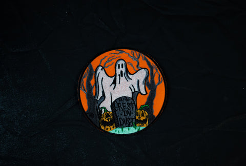 Close up of sheet ghost and jack o lanterns with headstone that reads, "Rest in dust"